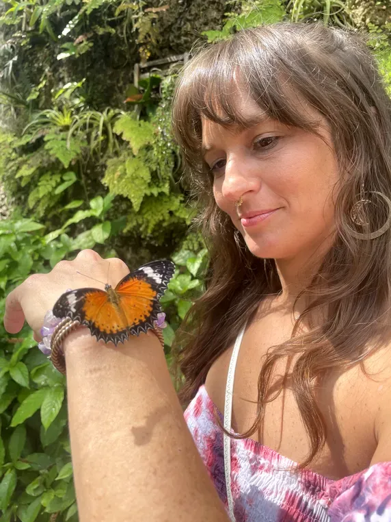 Jen Myers watching a butterfly resting on her hand